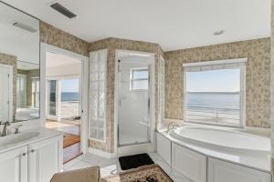 a bathroom with a tub and a shower and a window at Breathtaking Beach Front House home in St. Augustine