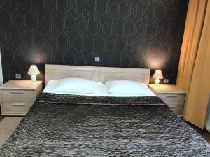 a bedroom with a large bed with two night stands at Hotell Wesenbergh in Rakvere