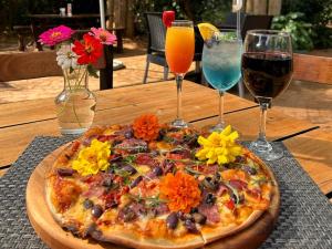 a pizza on a table with two glasses of wine at Fiddler's Green in Magoebaskloof