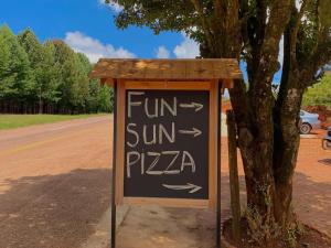 a sign that says fun sun pizza next to a tree at Fiddler's Green in Magoebaskloof