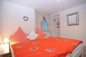 1 dormitorio con edredón naranja en la cama en Haus Oberkirchen, en Schmallenberg