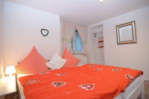 a bedroom with an orange comforter on a bed at Haus Oberkirchen Nähe Winterberg Skiliftkarussell in Schmallenberg