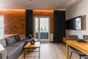 uma sala de estar com um sofá e uma parede de tijolos em Red Old Town Apartament em Elblag