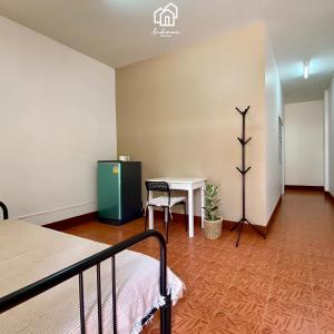 een kamer met een bed, een tafel en een bureau bij Andaman Residence in Thalang