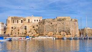 un gran edificio de piedra con barcos en el agua en Luxury Living Kennedy, en Gallipoli