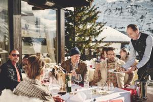 a man holding a plate of food at a restaurant at Burg Hotel Lech am Arlberg in Lech am Arlberg