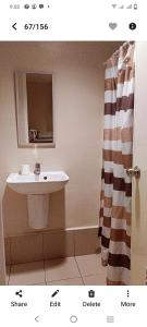 La salle de bains est pourvue d'un lavabo et d'un miroir. dans l'établissement SunVida Tower, à Cebu