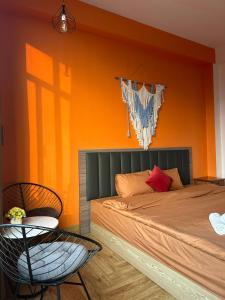 een slaapkamer met een bed met een oranje muur bij Thung Lũng Mây Tam Đảo in Vĩnh Phúc