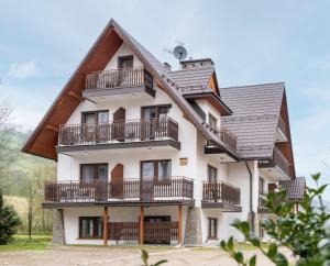 een huis met balkons en een dak bij Pokoje u Kamińskich 26E in Zakopane