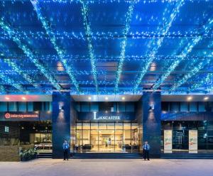 two men standing in front of a building with blue lights at Modern Studio Apartment in Hanoi