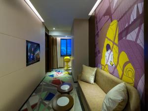 a living room with a couch and a colorful wall at Zmax Qingyuan Guangqing Railway Station in Qingyuan
