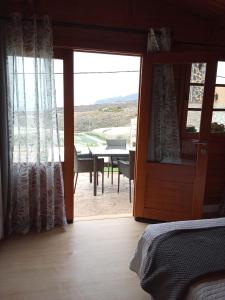 a bedroom with a door open to a patio with a table at El Refugio in Guía de Isora