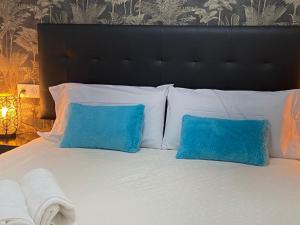 1 cama con almohadas blancas y almohadas azules en Gran Vía Urban Apartments, en Madrid