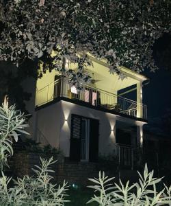a white house with a balcony at night at Green oasis Deda Božo in Rovinj
