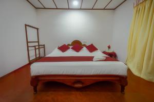 a bedroom with a large bed with red pillows at Sawani Home in Ambalangoda