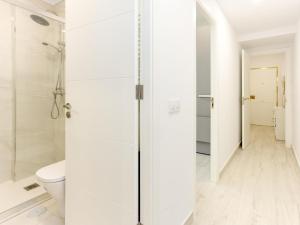a white bathroom with a shower and a toilet at 18 Beautiful Costa Rica Apartment Madrid in Madrid