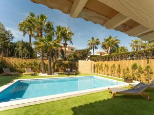 a swimming pool in a yard with palm trees at Casa Pinsa - Großzügiges mediterran-stilvolles Ferienhaus mit eigenem Pool in Puig de Ros in Llucmajor