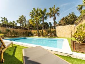 a swimming pool in a yard with palm trees at Casa Pinsa - Großzügiges mediterran-stilvolles Ferienhaus mit eigenem Pool in Puig de Ros in Llucmajor +12 photos