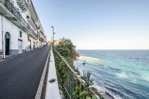 uma rua vazia ao lado de um corpo de água em A Fenestella Caprese - Sea View em Capri