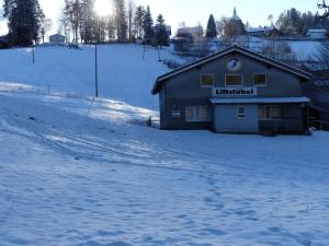 un edificio en la nieve con el sol en el fondo en Haus Gisela en Forbach