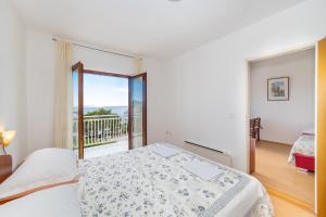 een slaapkamer met een bed en een balkon bij Apartments Palmero in Gradac