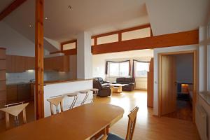 a kitchen and living room with a table and chairs at Hotel Hornstein - Weingut, Vinothek & Gastronomie in Nonnenhorn