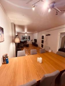 una gran mesa de madera en una sala de estar con sillas en Komplett leilighet ved Tiller, en Trondheim