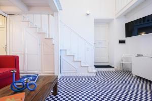 uma sala de estar com uma escada e uma tesoura azul numa mesa em A Fenestella Caprese - Sea View em Capri