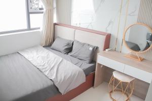 a bedroom with a bed with a mirror and a desk at Ly Homestay - Nera Garden Huế in Hue