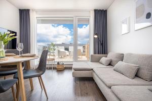 a living room with a couch and a table at SMILGA & KOPA home - Mano jūra 2 Kunigiškiai - by Hello Sea homes in Palanga