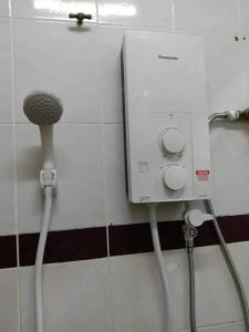 La salle de bains est pourvue d'une douche avec flexible d'eau. dans l'établissement HOMESTAY ANGGUN SAFIYYA, à Bayan Lepas