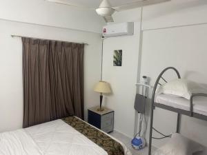 - une chambre avec des lits superposés, une lampe et une fenêtre dans l'établissement HOMESTAY ANGGUN SAFIYYA, à Bayan Lepas