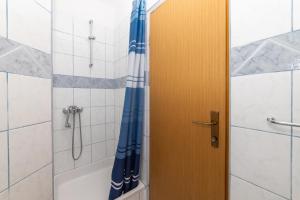 een badkamer met een douche en een blauw douchegordijn bij Apartments Palmero in Gradac