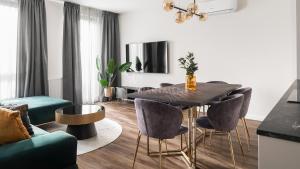 uma sala de estar com uma mesa de jantar e cadeiras em Lion Apartments - SCALA City Center Apartments&Parking IK em Gdansk