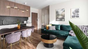 uma sala de estar com um sofá verde e uma mesa em Lion Apartments - SCALA City Center Apartments&Parking IK em Gdansk