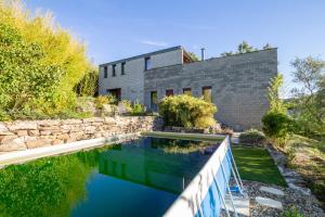 a house with a swimming pool in front of it at La Maison des Chataigniers in Meyrannes