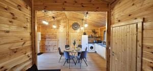 a kitchen and dining room with a table and chairs at Chalet Istres des Ardennes in Fromelennes