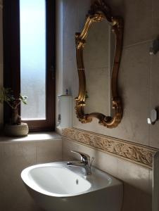 baño con lavabo y espejo en la pared en Agriturismo Casa Rastelli, en Monteorsello