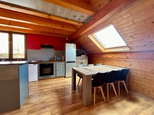 een keuken met een tafel en stoelen in een kamer bij Chez Fred - CLG Savoie - 2Ch - 1 SDB in Chevillard