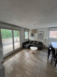 een woonkamer met een bank en een tafel bij Charmant F2 Port Marianne (15 Min Plages/Centre-ville) in Montpellier