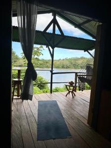 eine Veranda mit einer Matte, einer Hängematte und Wasser in der Unterkunft La Mariola - Finca Agroecológica in El Castillo de La Concepción