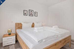 1 dormitorio con 1 cama con sábanas blancas y toallas en An der Haffküste Haffkoje, en Zirchow
