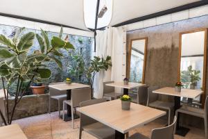 a restaurant with tables and chairs and plants at The Convo Lake Como in Como