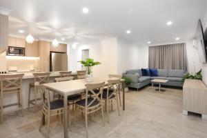 ゴールドコーストにあるSouthport Motel & Apartmentsのテーブルと椅子のあるキッチンとリビングルーム +24枚の写真