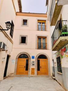 a building with orange doors on a street at APARTAMENTOS TURíSTICOS MONTASOL 1 in Montánchez