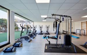 a gym with a row of treadmills and exercise bikes at Hotel Samba in Lloret de Mar