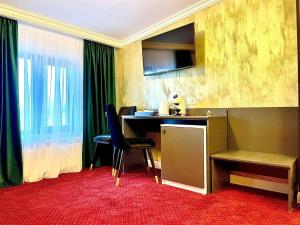 a hotel room with a desk and chairs and a window at Hotel City Break in Galaţi