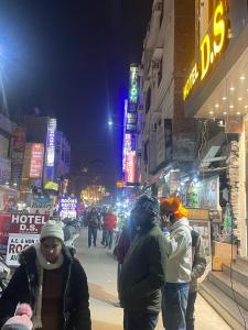 a group of people walking down a city street at night at HOTEL D.S in Amritsar