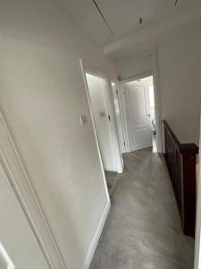 um corredor com um frigorífico branco num quarto em 30 min STN or to central London em Enfield Lock