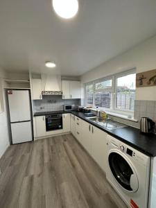 a large kitchen with a washer and dryer in it at 30 min STN or to central London in Enfield Lock
